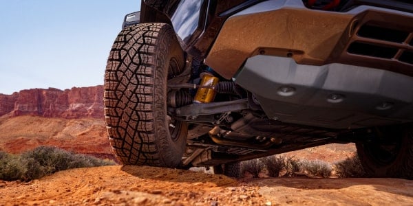 Close-up of the front tire, suspension and skid plate on a 2027 Chevrolet Silverado 1500 ZR2