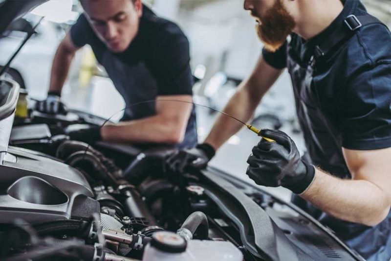 Technicians working on a vehicle engine