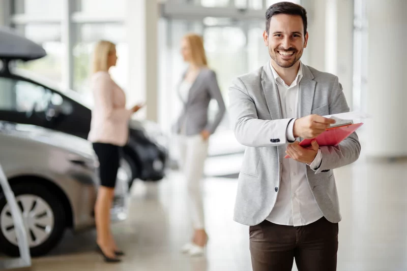 Sales consultant greeting customers in a dealership showroom