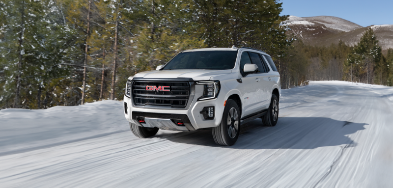 GMC SUV driving on a snowy road