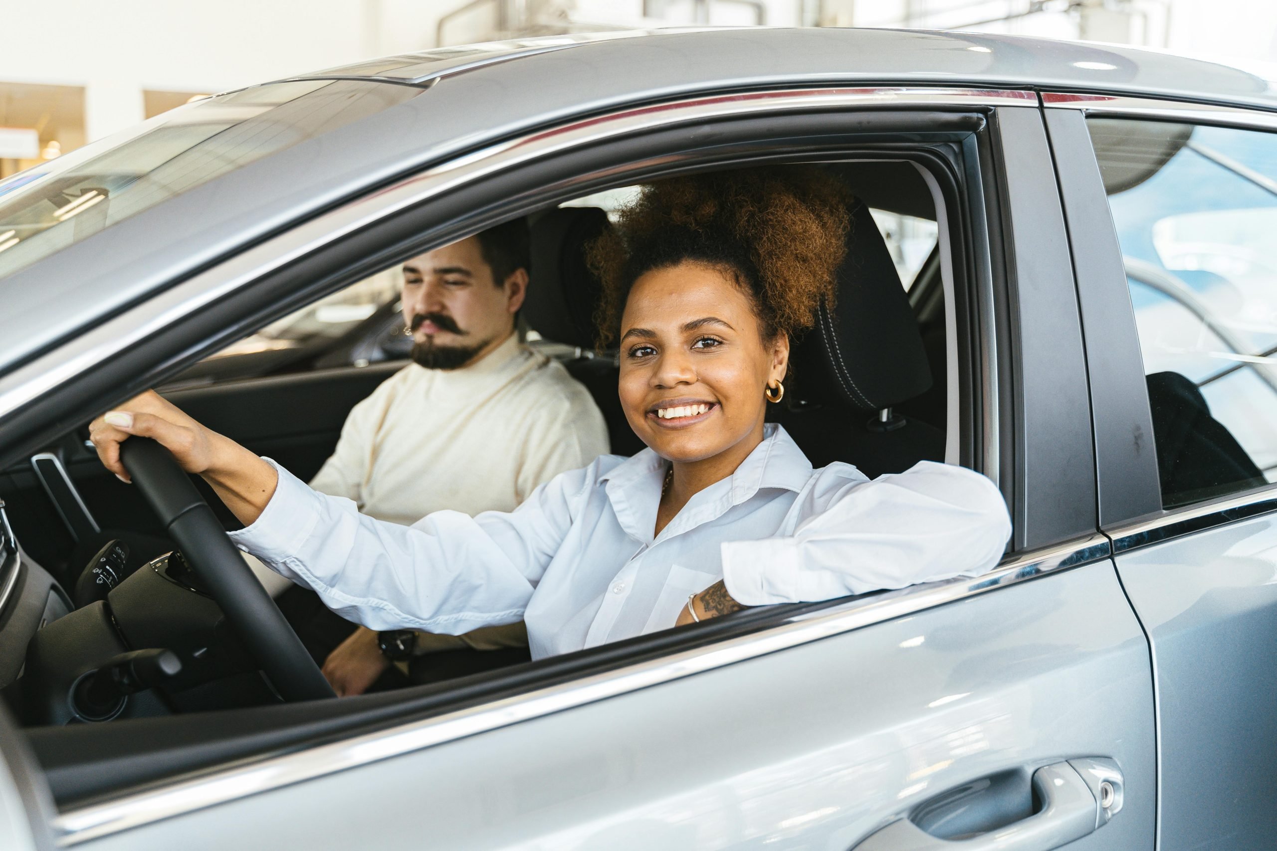 A happy customer behind the wheel of her new vehicle