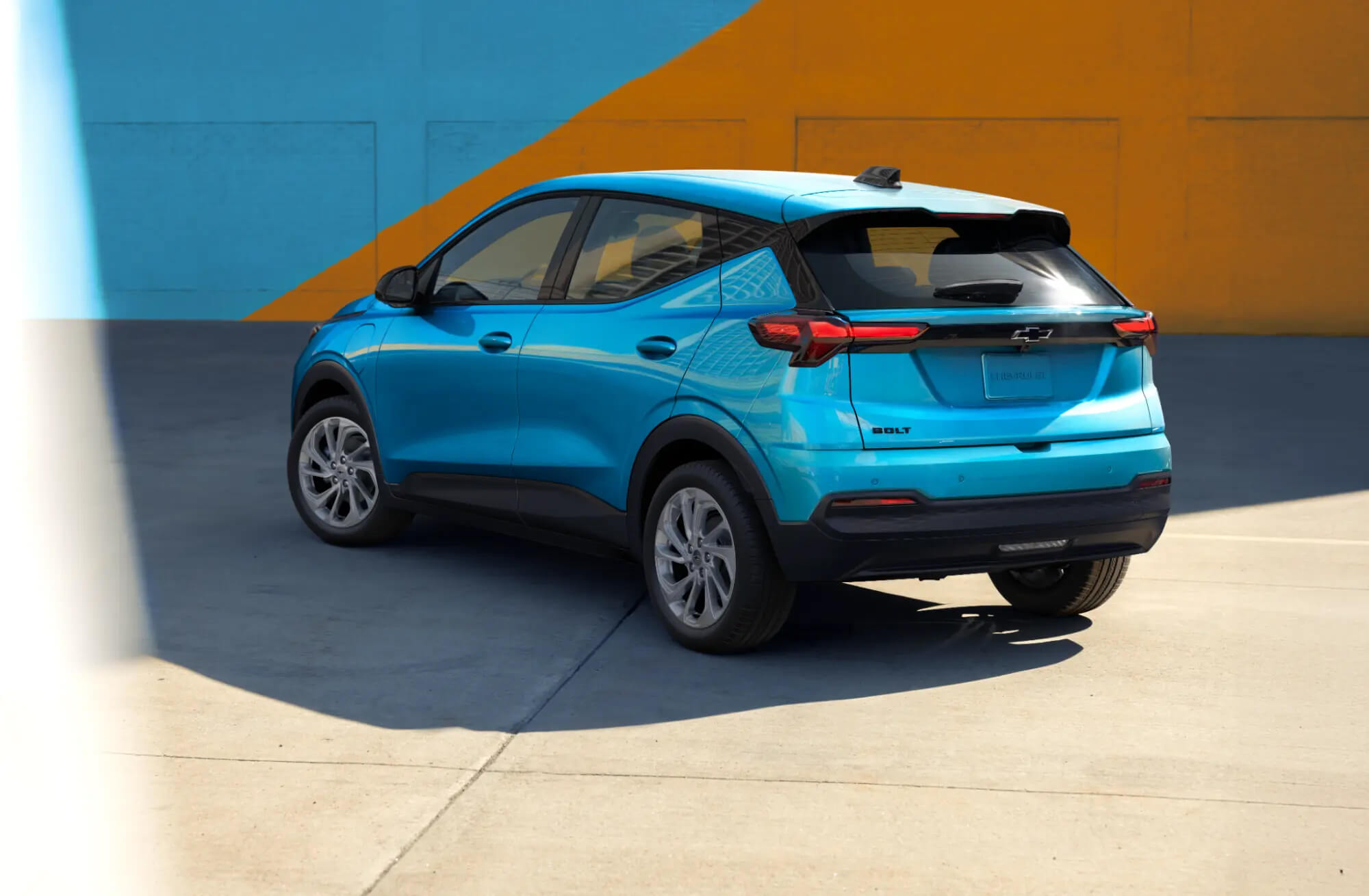 Blue Chevrolet Bolt parked in front of a colourful wall