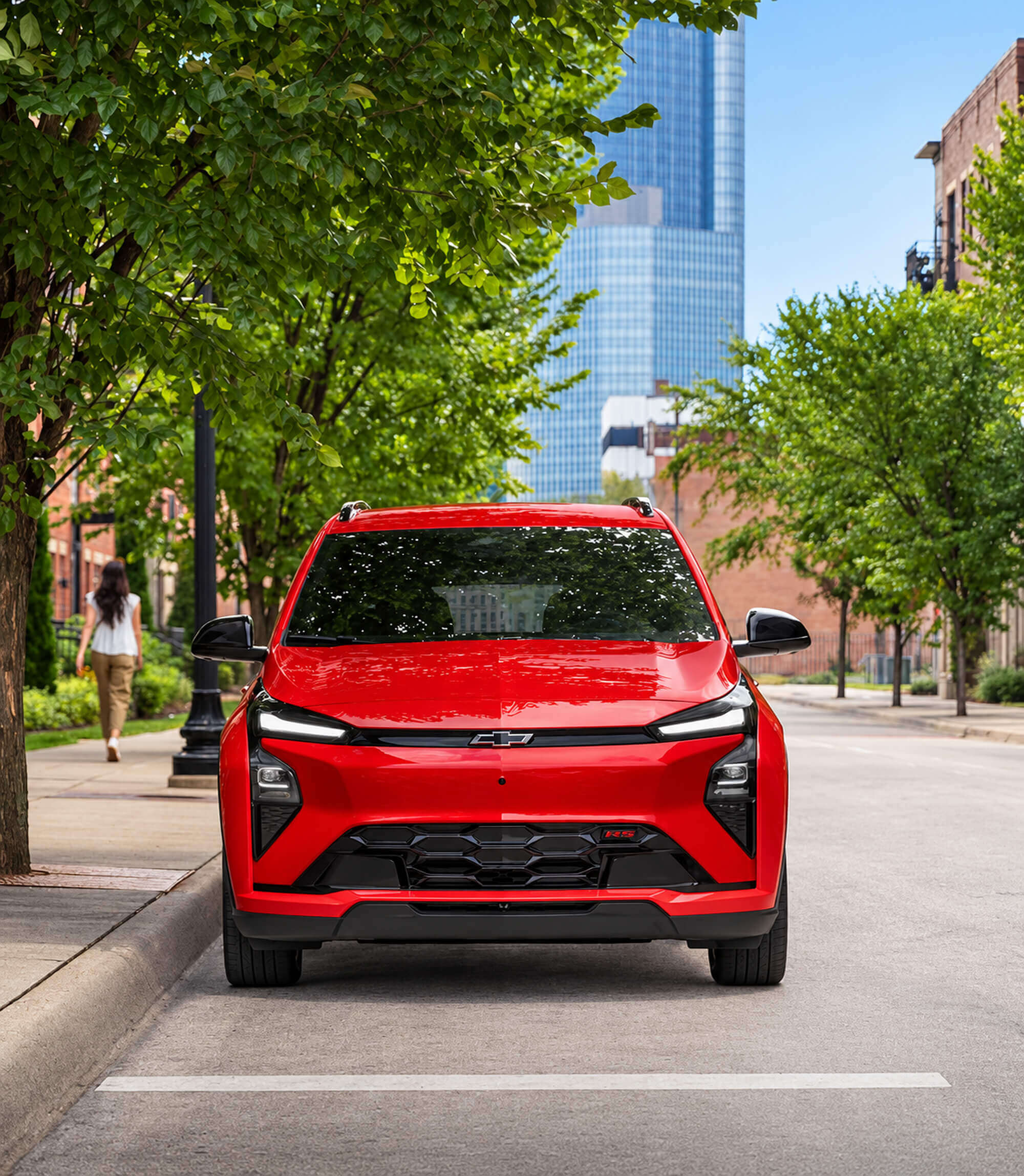 Red Chevrolet Bolt driving on a city street