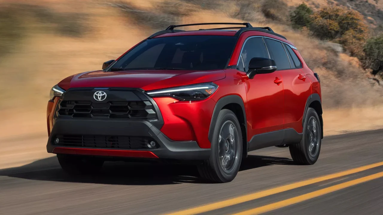 Toyota Corolla Cross hybride 2026 rouge circulant sur la route.
