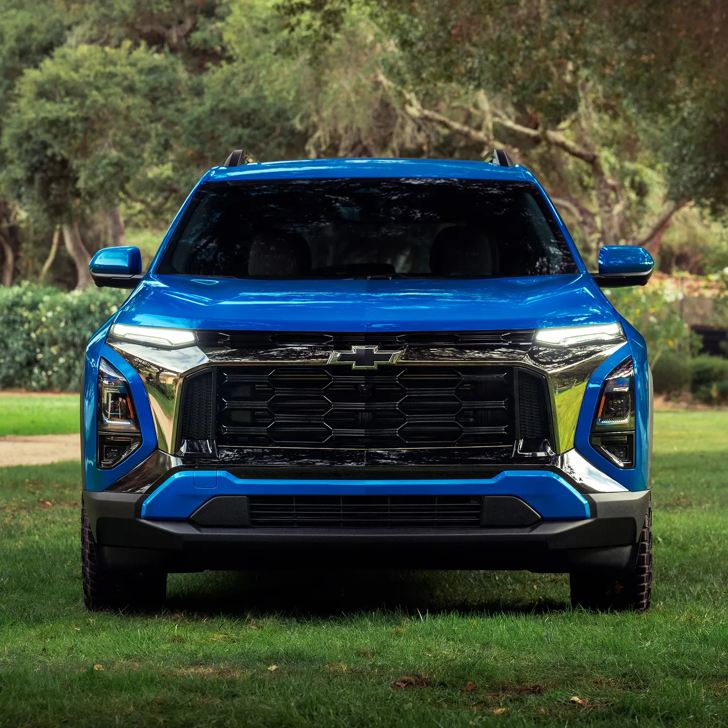Vue avant du Chevrolet Equinox 2027 bleu sur un terrain gazonné.