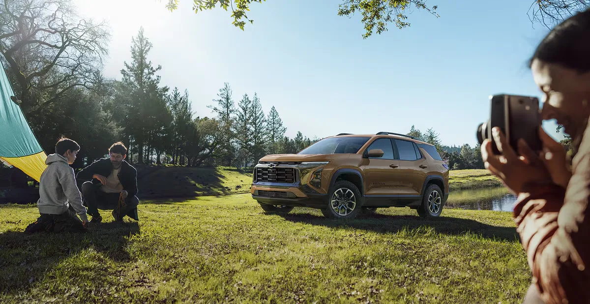 Chevrolet Equinox 2027 près d'une famille en camping.