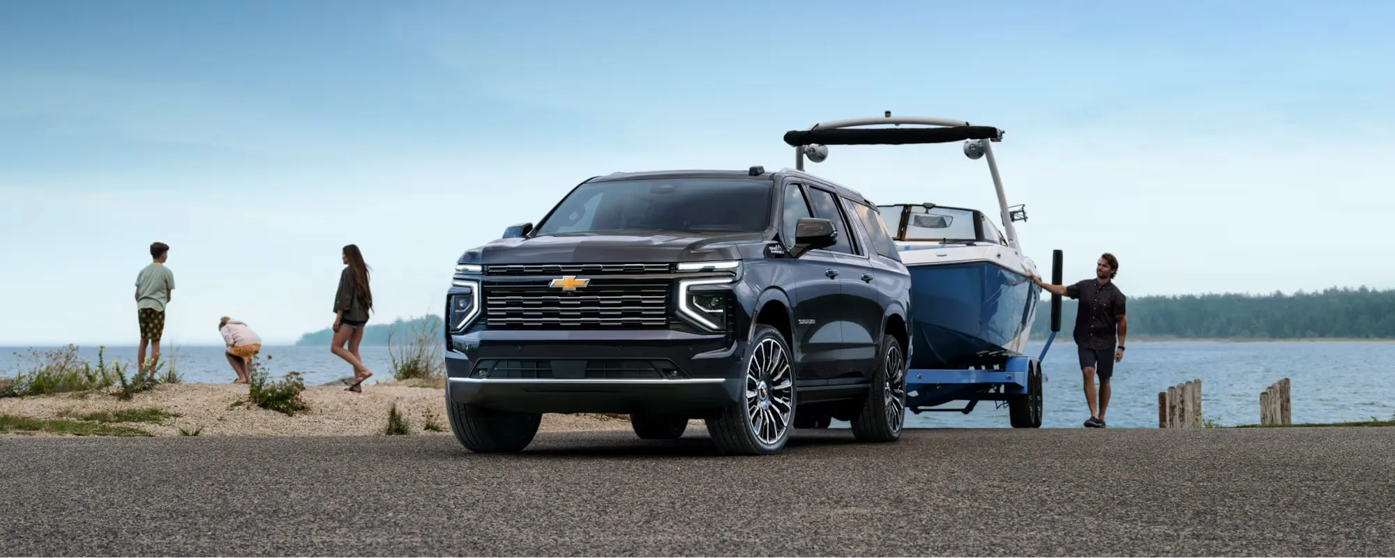 Chevrolet Suburban 2026 remorquant un bateau près de l’eau.
