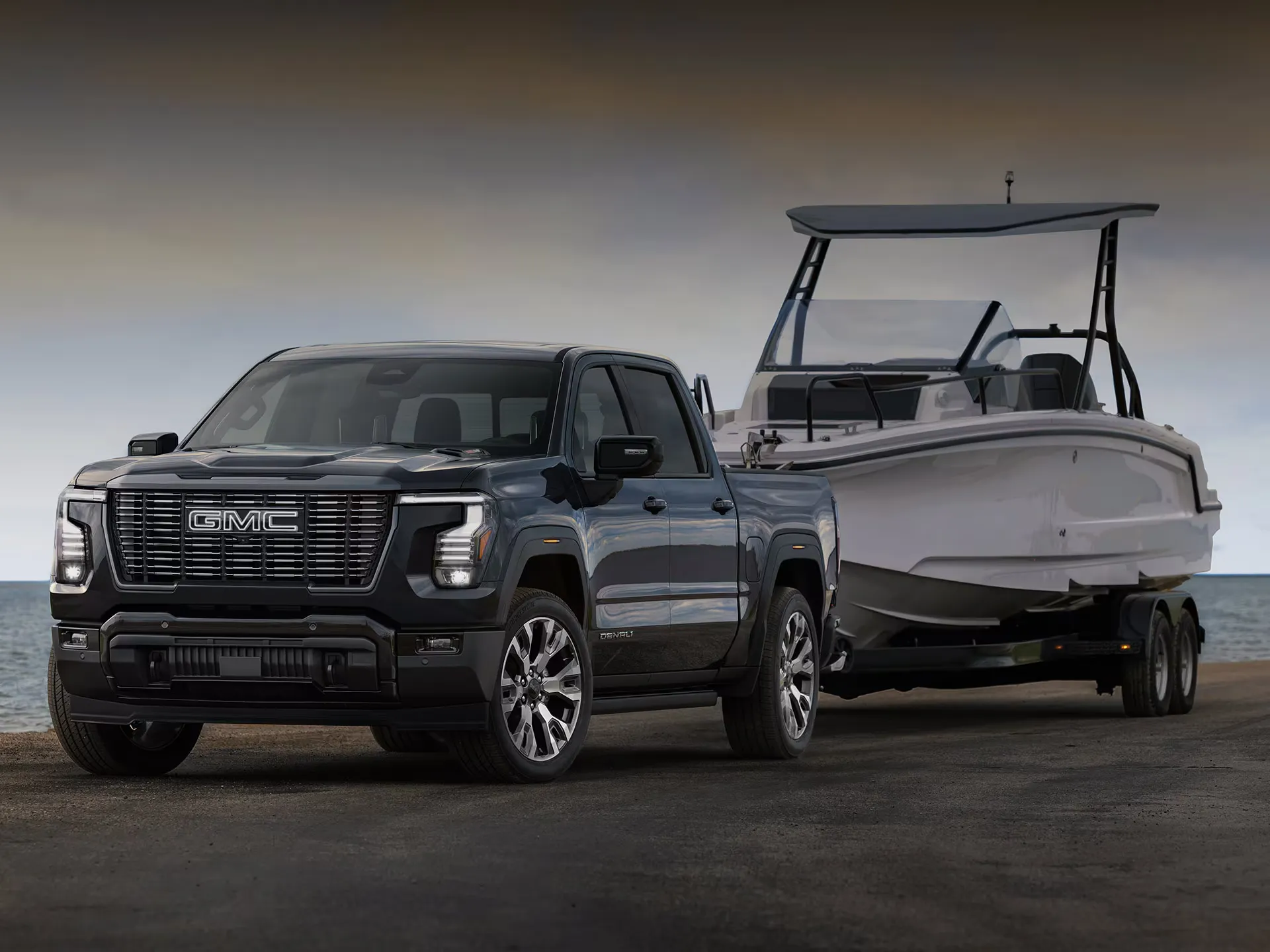 GMC Sierra 1500 2027 remorquant un bateau au bord de l’eau.