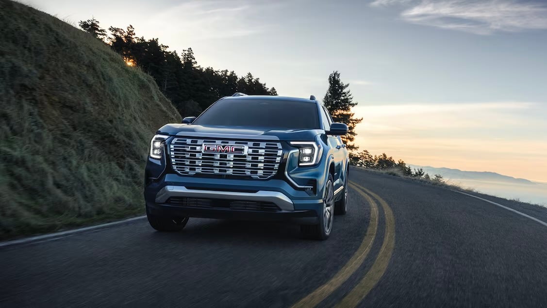 GMC Terrain 2026 bleu roulant sur une route panoramique.