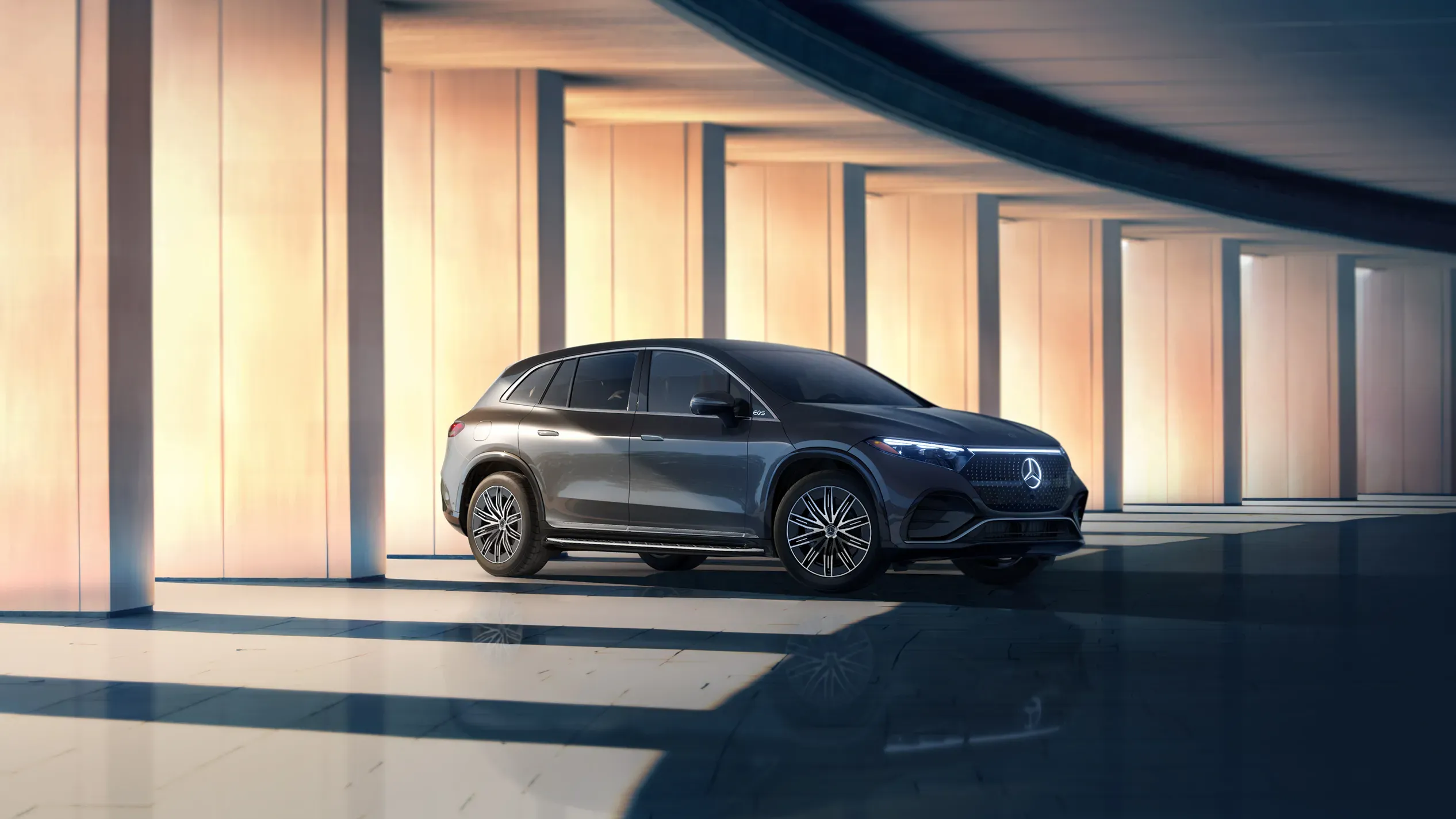Mercedes-Benz EQS 2026 électrique devant un édifice illuminé.